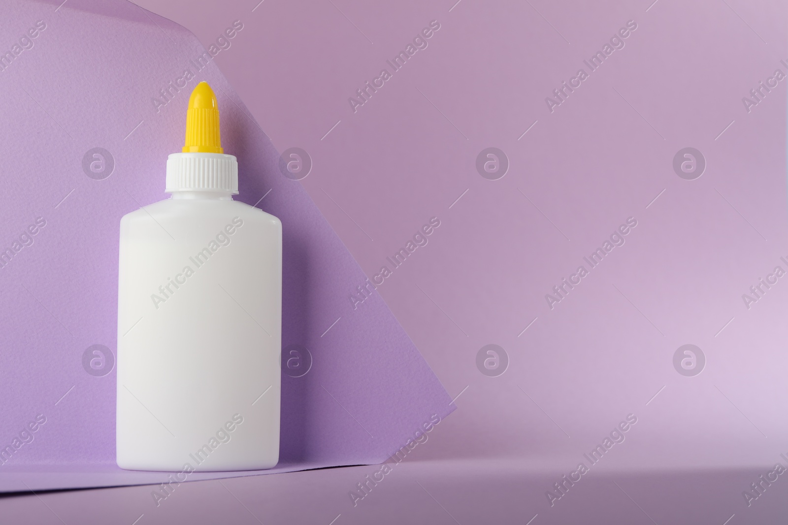 Photo of One bottle of glue on violet background, space for text