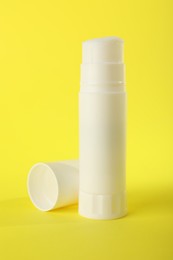 Photo of Glue stick and cap on yellow background