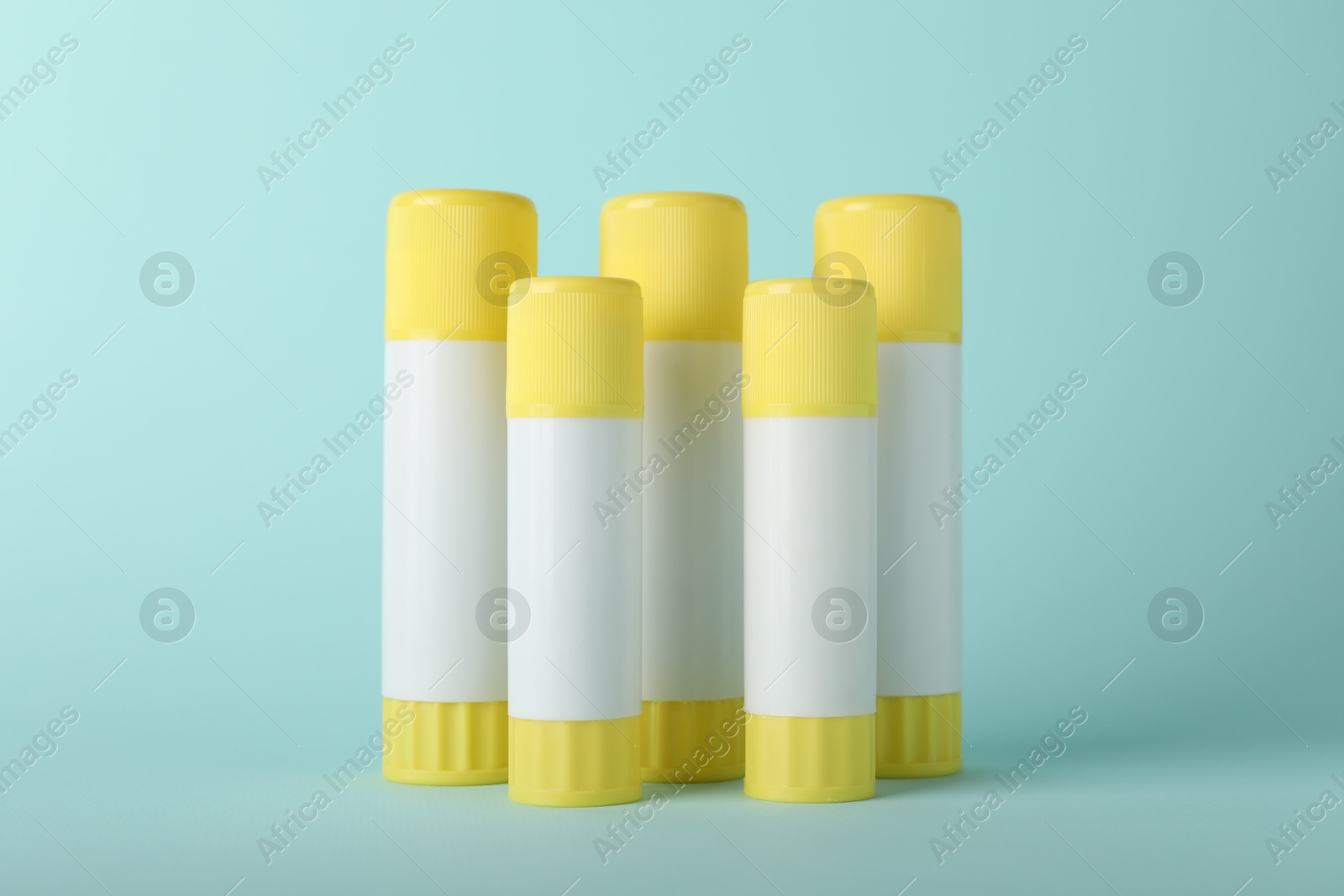 Photo of Many glue sticks on light blue background