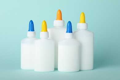 Photo of Bottles of glue on light blue background