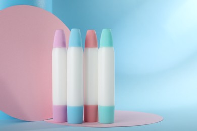 Photo of Many different glue sticks and paper cutouts on light blue background