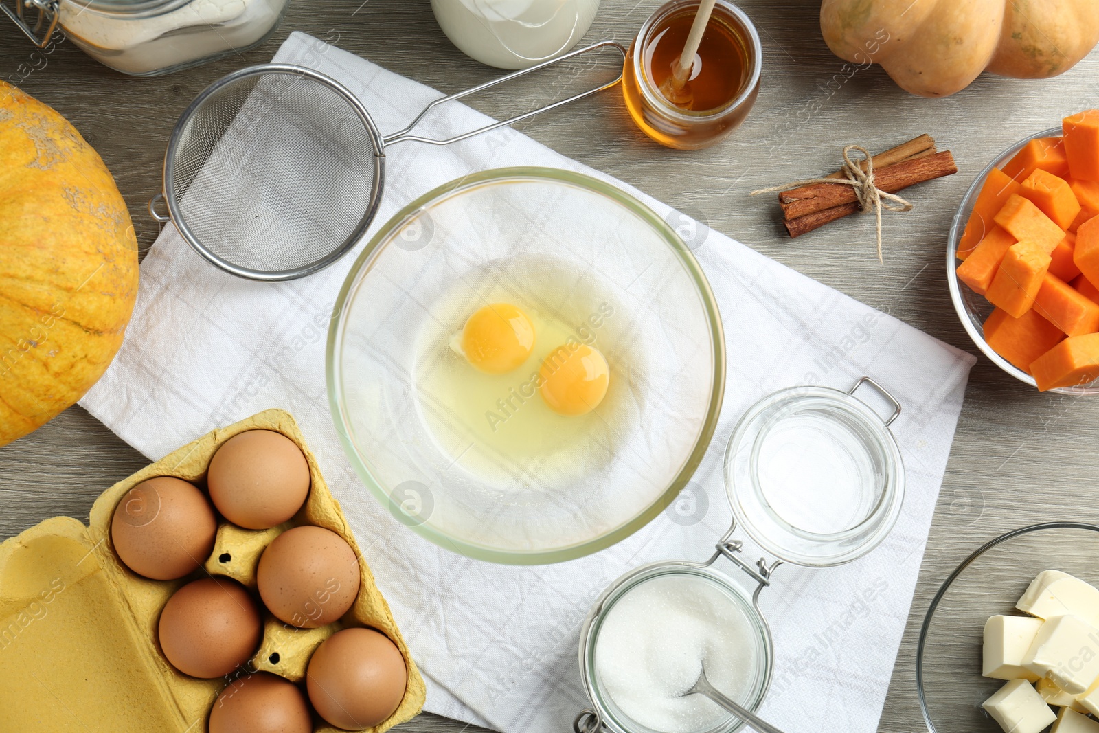 Photo of Different ingredients for pumpkin pancakes on wooden table, flat lay