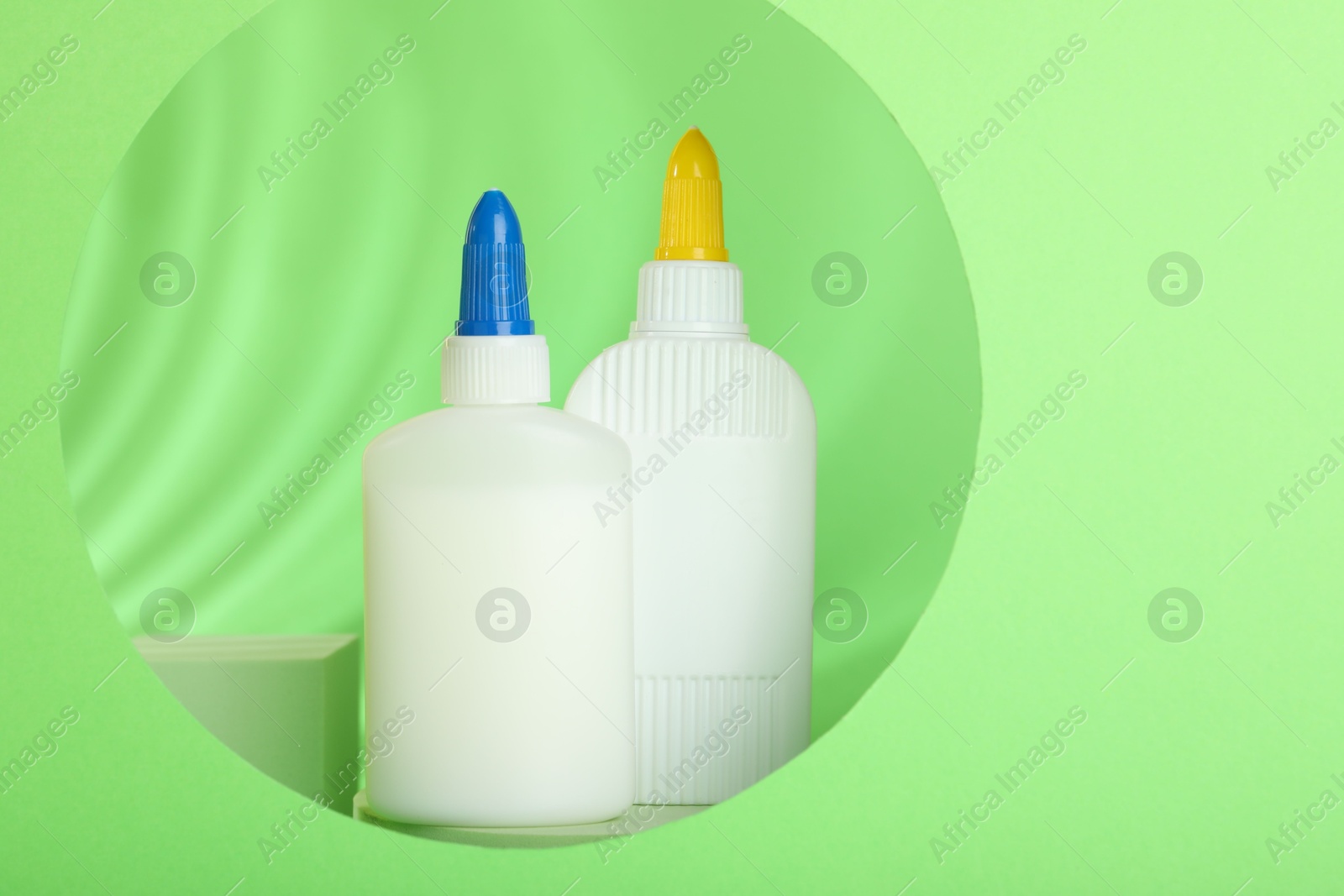 Photo of Bottles of glue on light green background