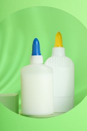 Photo of Bottles of glue on light green background