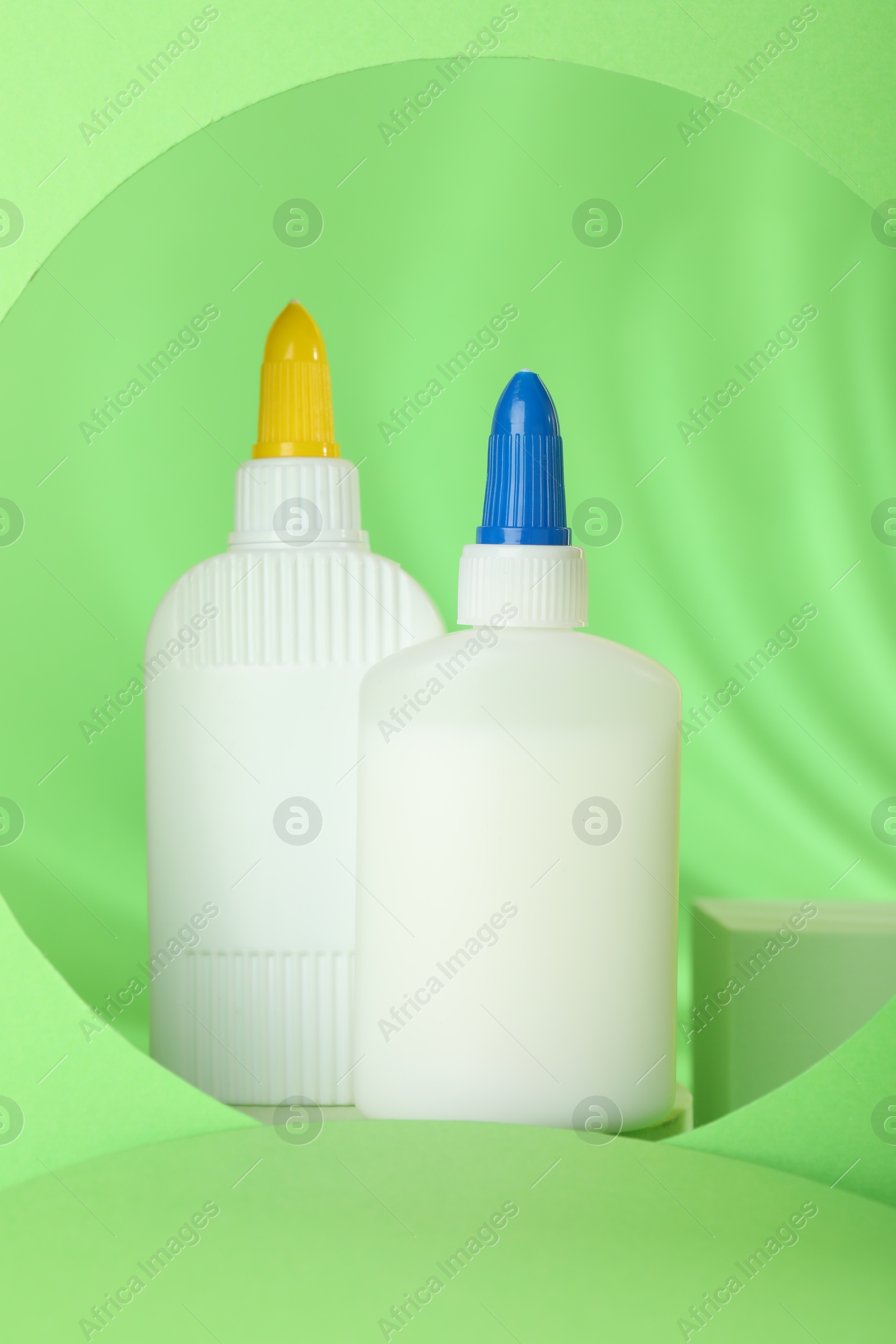 Photo of Bottles of glue on light green background