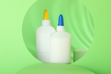 Photo of Bottles of glue on light green background