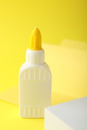 Photo of One bottle of glue on yellow background