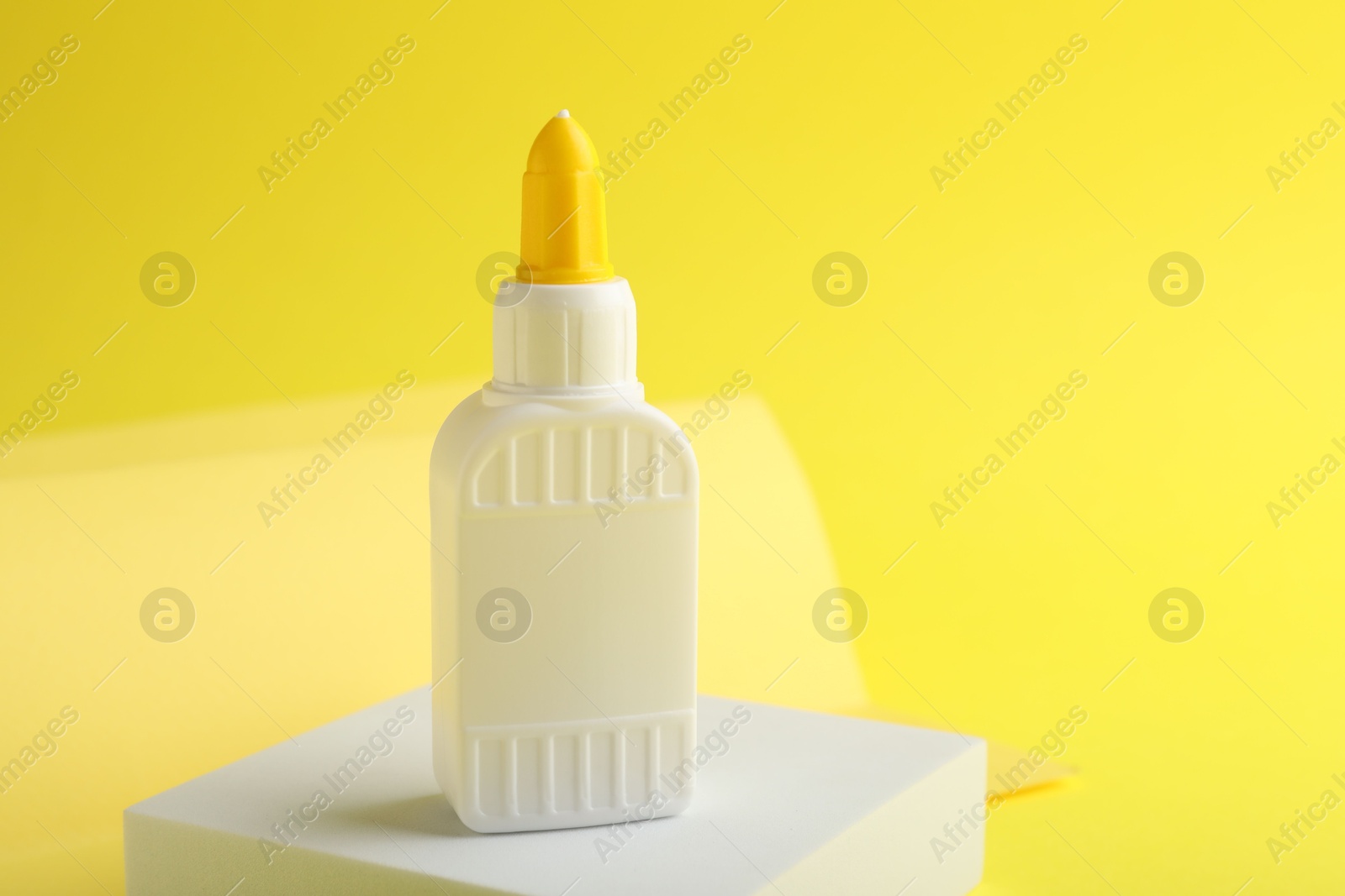 Photo of One bottle of glue on yellow background. Space for text