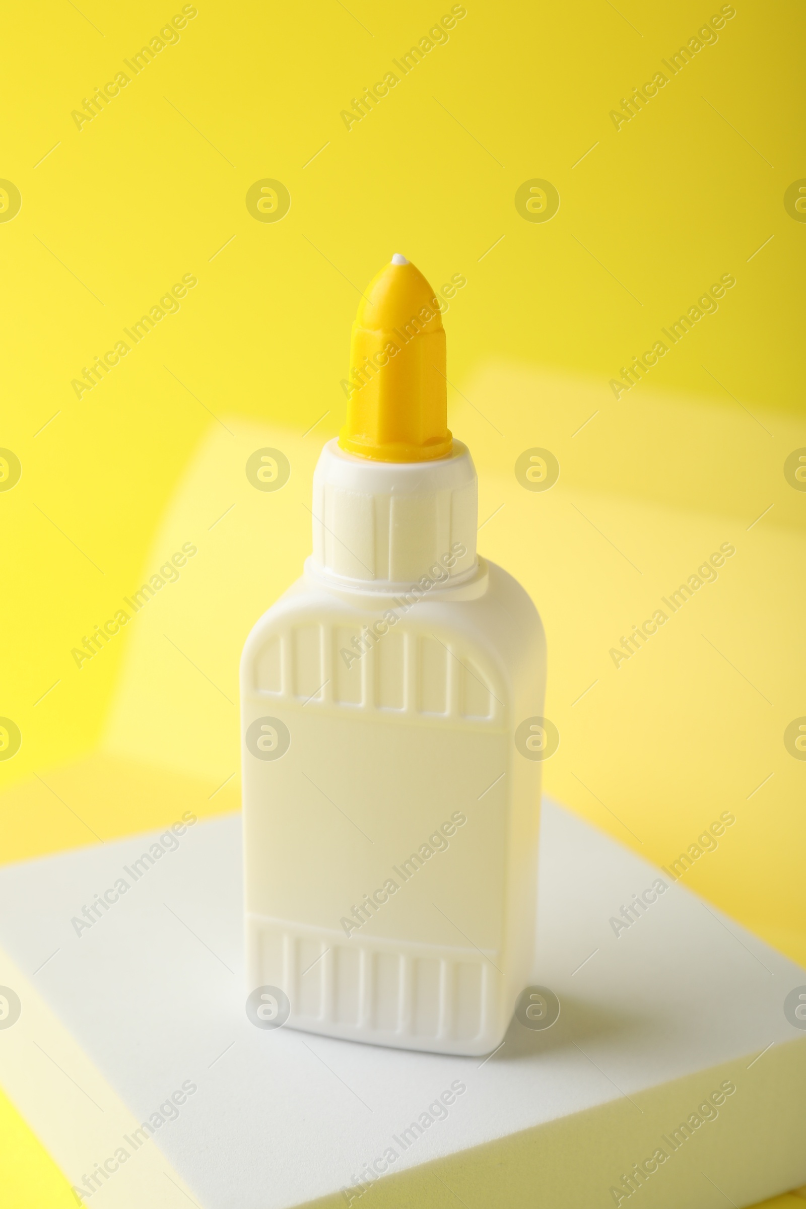 Photo of One bottle of glue on yellow background