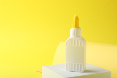 Photo of One bottle of glue on yellow background