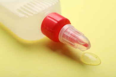 Photo of Bottle of glue on yellow background, closeup