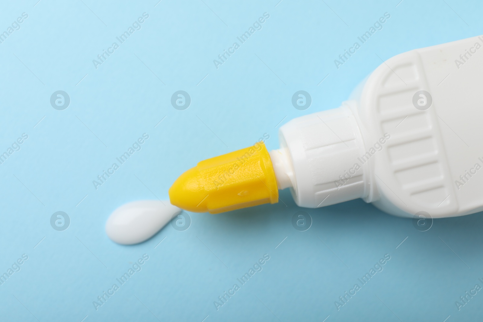 Photo of Bottle of glue on light blue background, top view