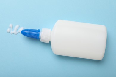 Photo of Bottle of glue on light blue background, top view