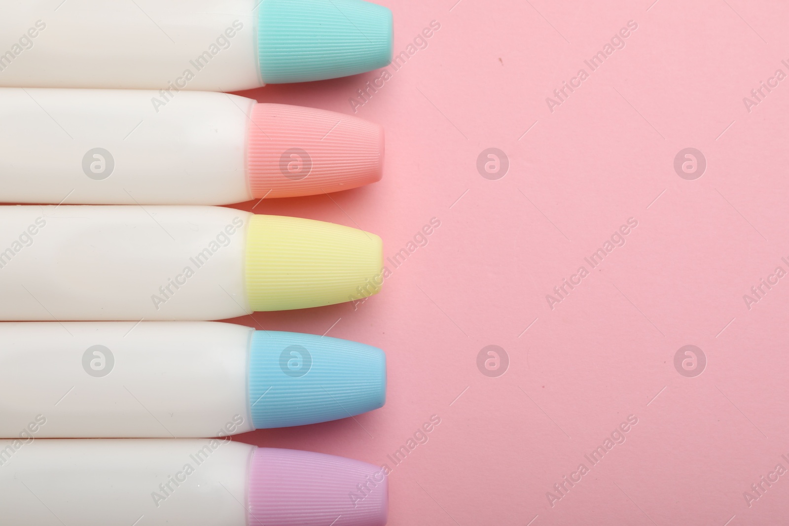 Photo of Sticks of glue on pink background, flat lay. Space for text