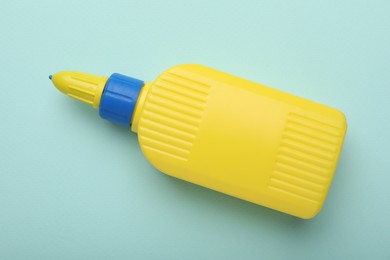 Photo of Bottle of glue on light blue background, top view