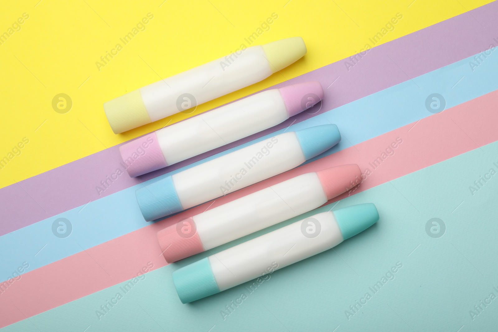 Photo of Sticks of glue on color background, flat lay