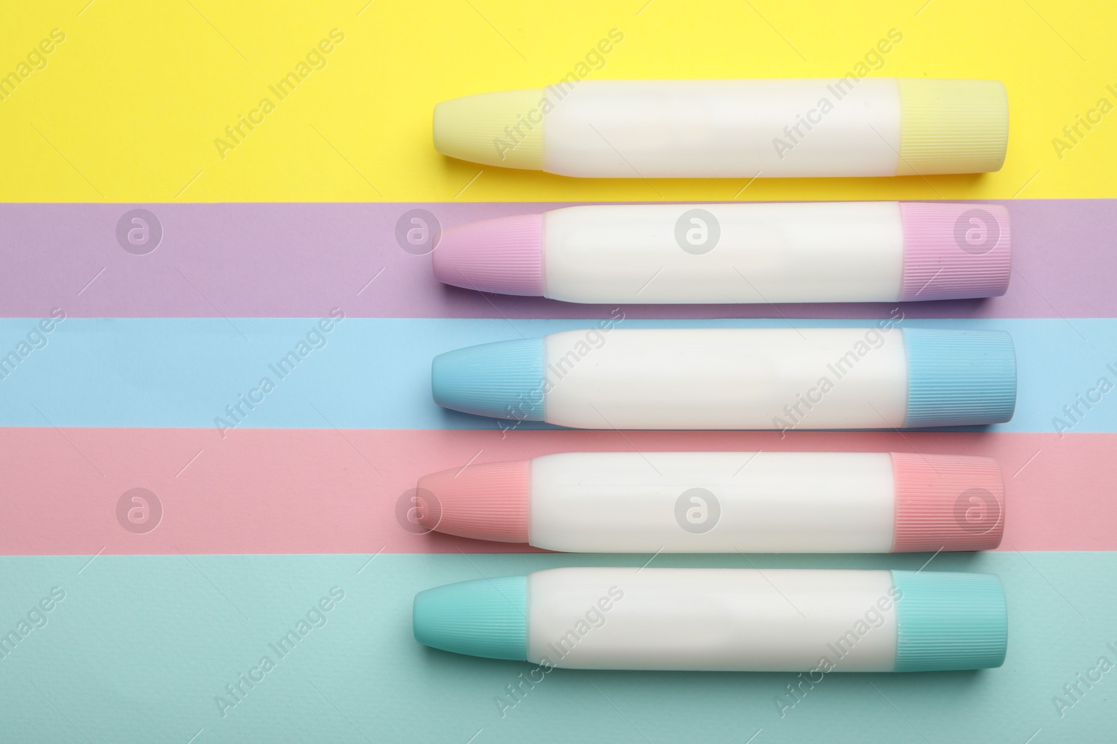 Photo of Sticks of glue on color background, flat lay