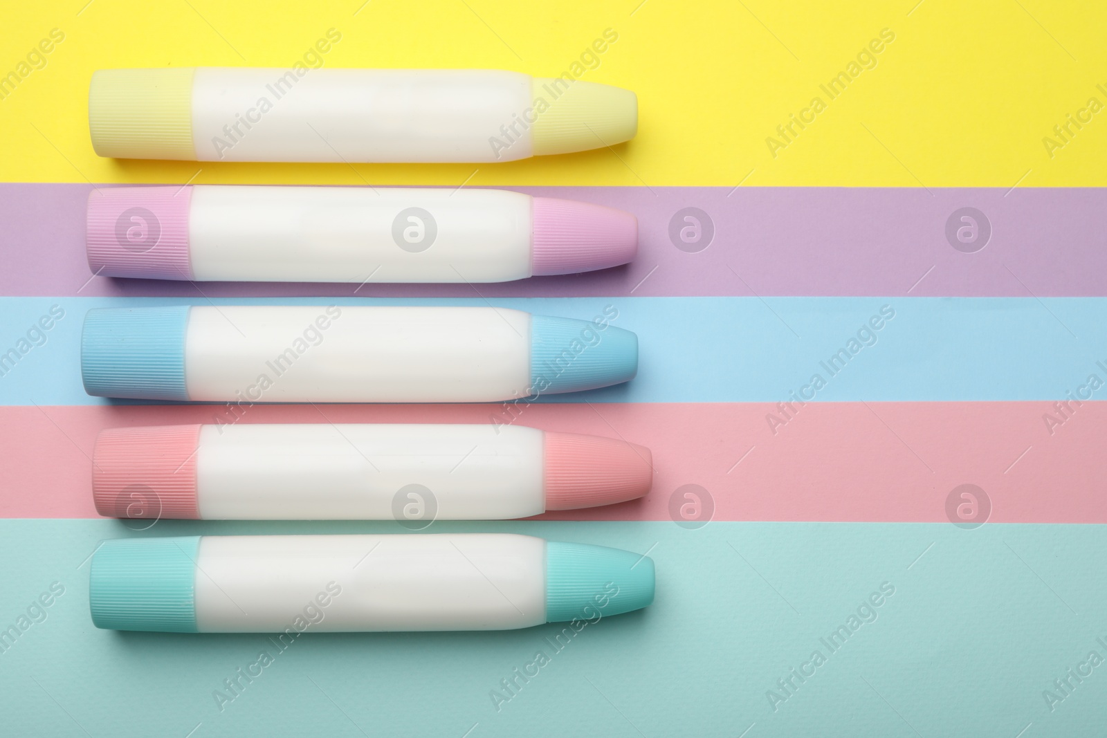 Photo of Sticks of glue on color background, flat lay