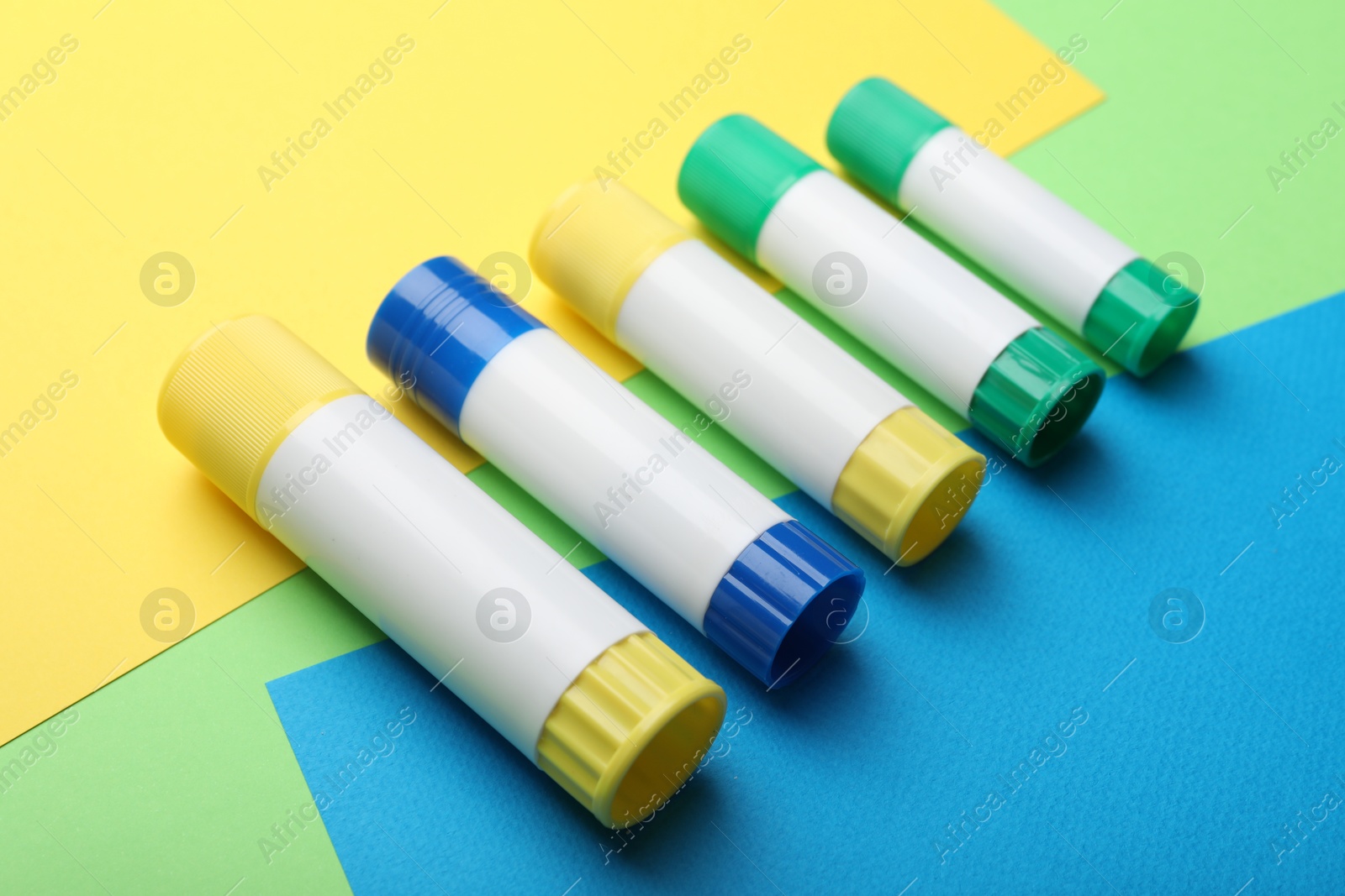 Photo of Many sticks of glue on color background