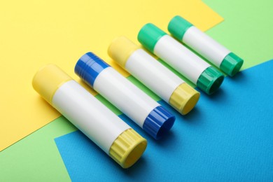 Photo of Many sticks of glue on color background