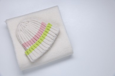 Photo of Stylish knitted hat and warm scarf on white background, top view. Space for text