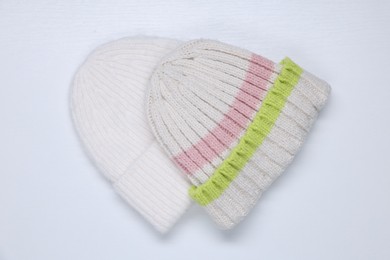 Photo of Stylish knitted hats on white background, top view