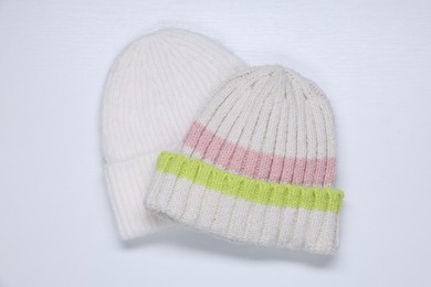 Photo of Stylish knitted hats on white background, top view