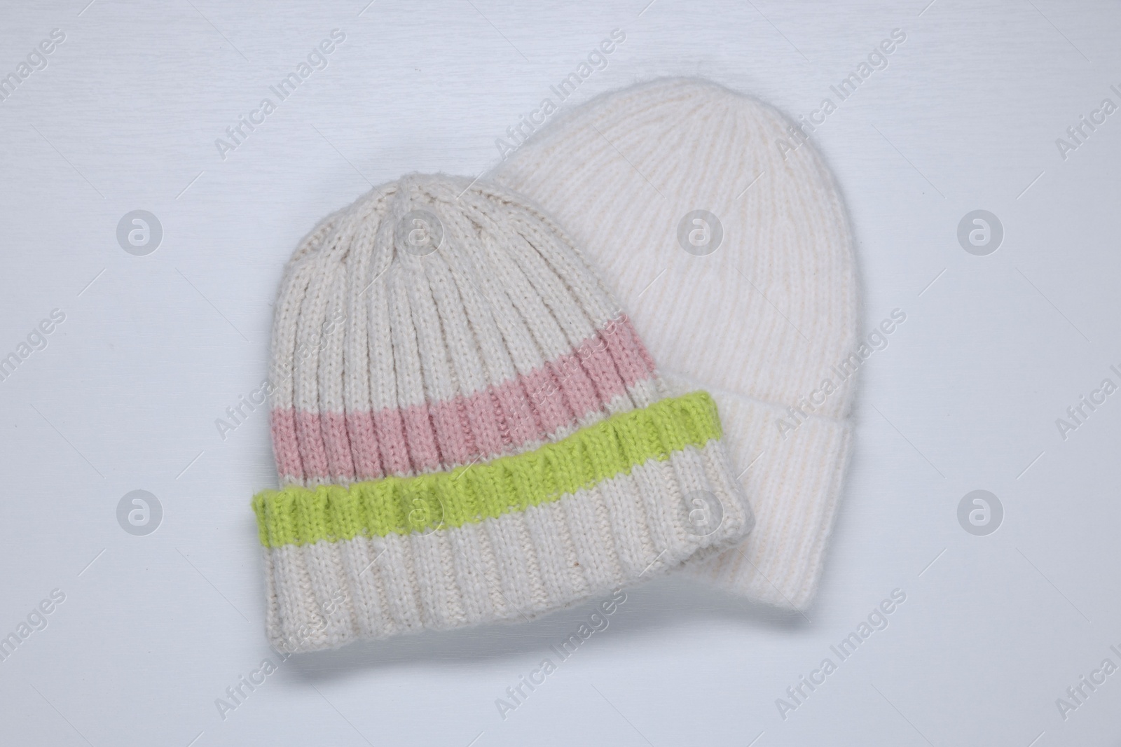 Photo of Stylish knitted hats on white background, top view