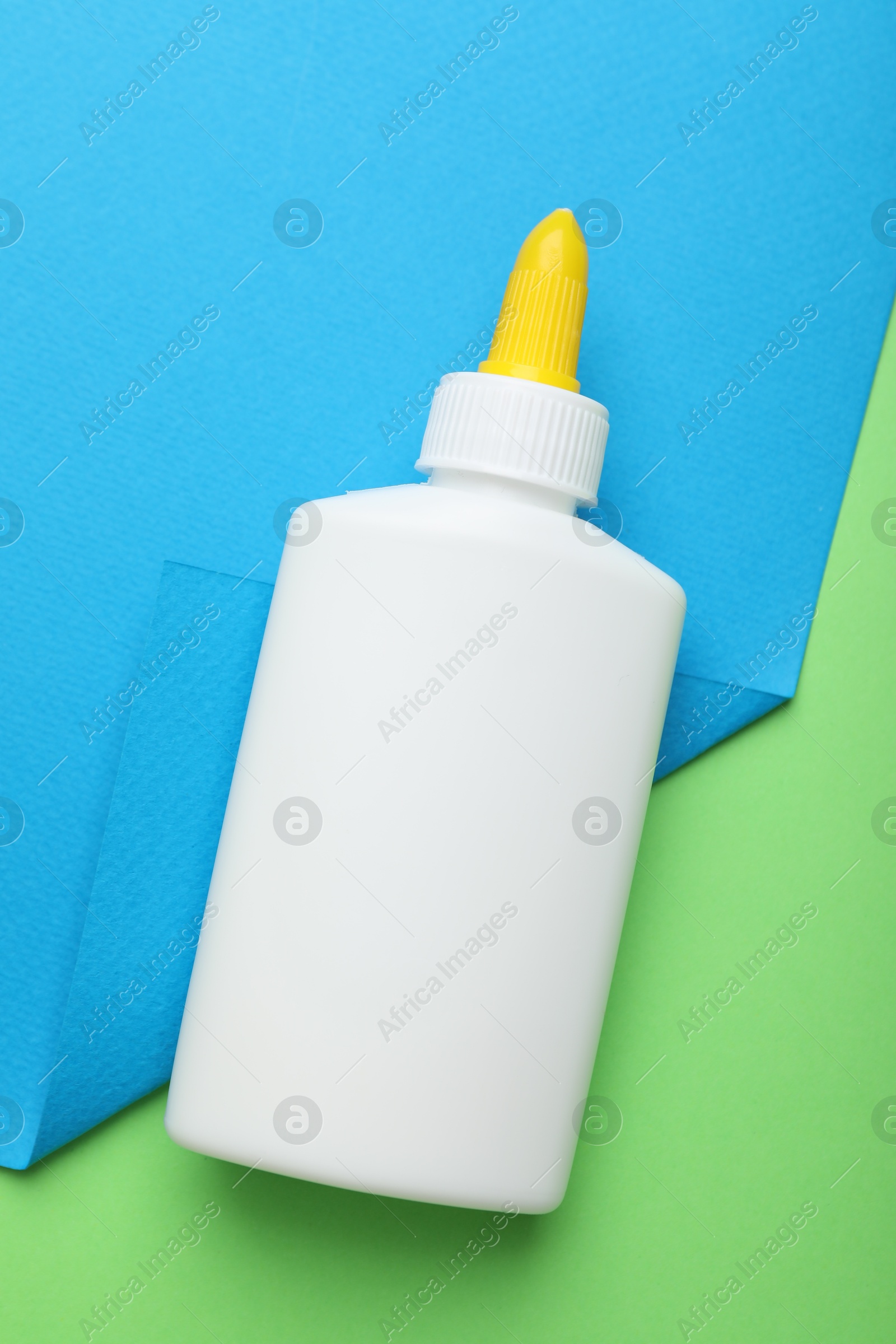 Photo of Bottle of glue on color background, top view