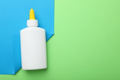 Photo of Bottle of glue on color background, top view. Space for text