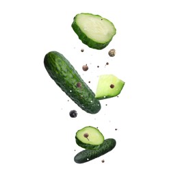 Image of Cucumber, salt and peppercorns in air on white background