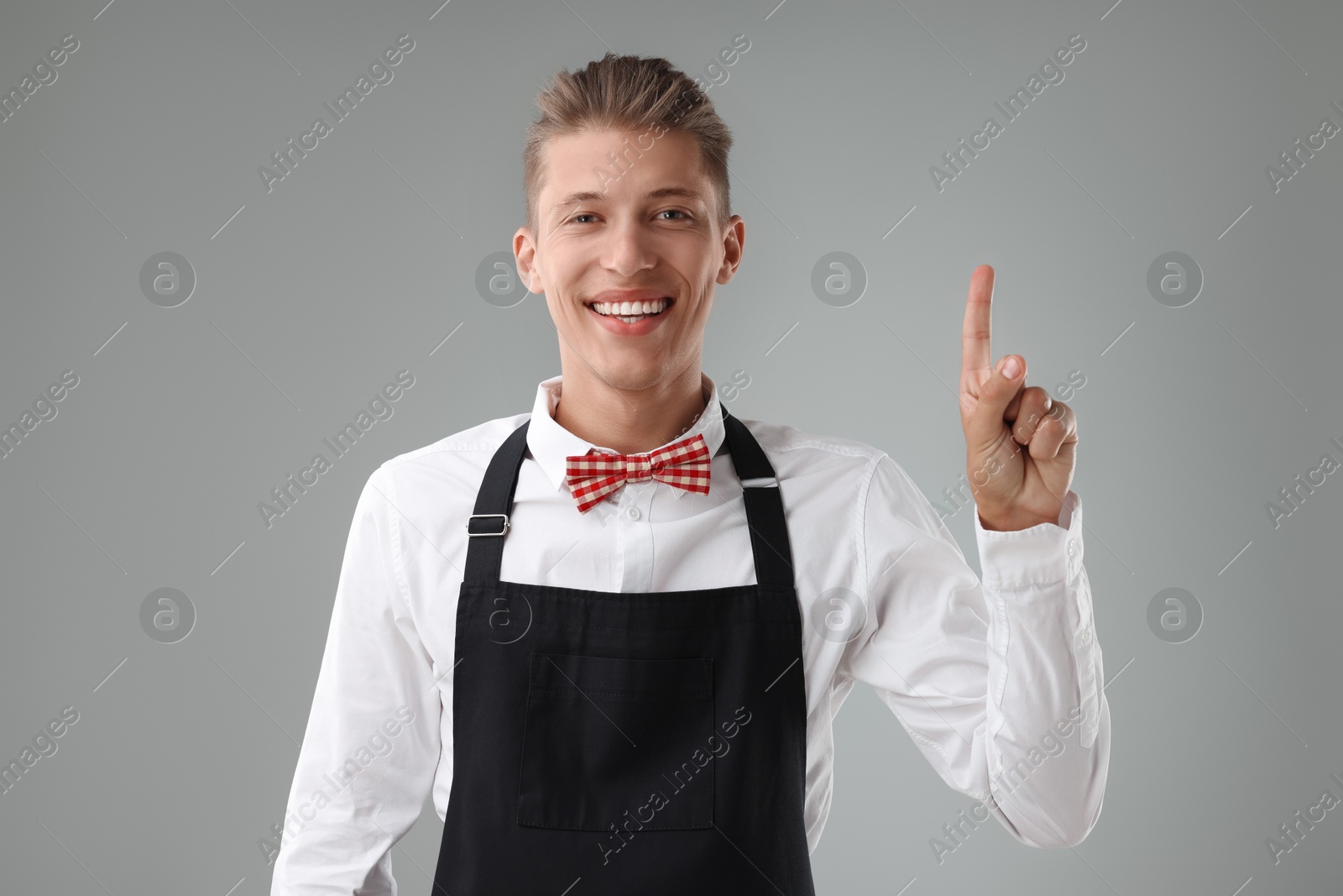 Photo of Portrait of smiling fast-food worker on gray background