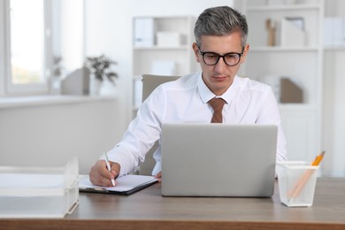 Middle aged man working at table in office