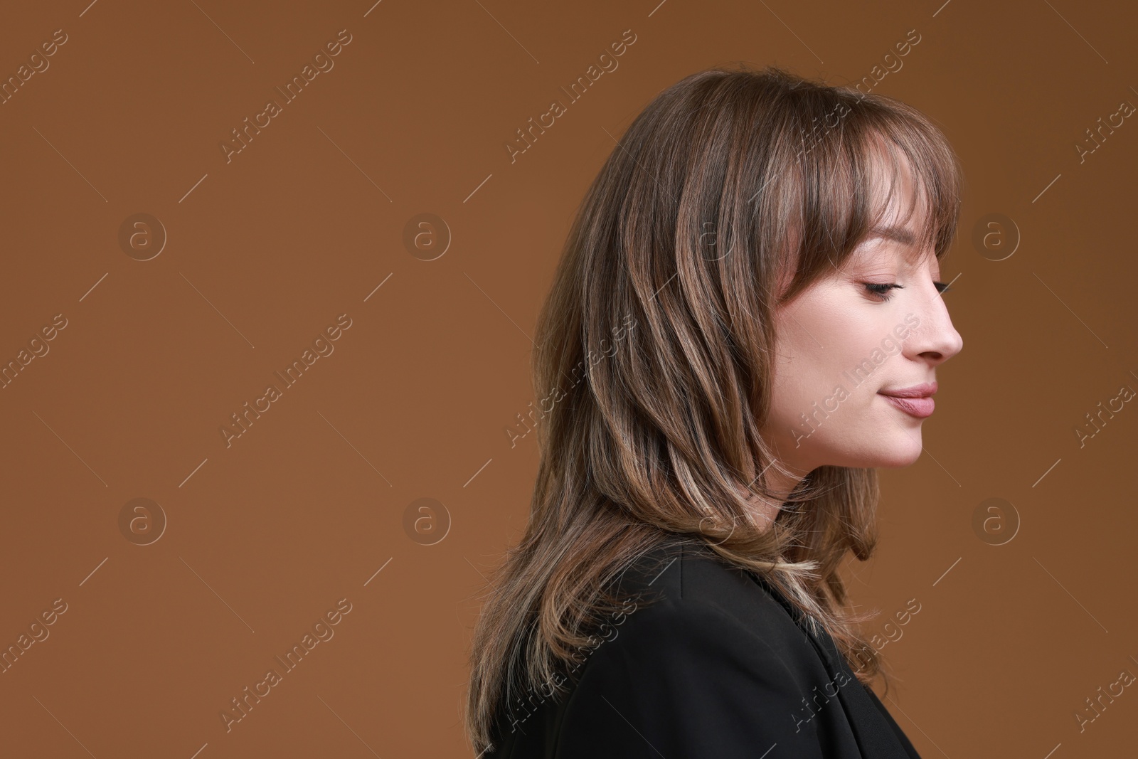 Photo of Attractive woman with stylish haircut on brown background, space for text