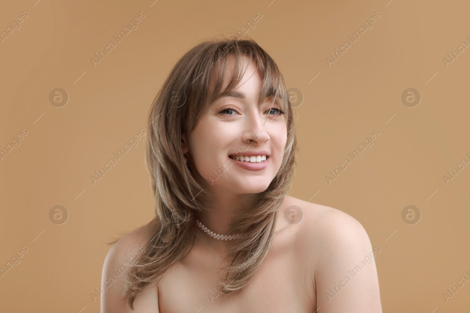 Photo of Attractive woman with stylish haircut on beige background