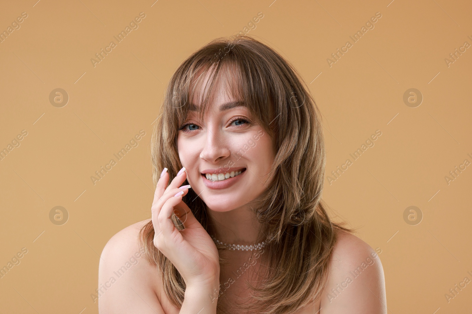 Photo of Attractive woman with stylish haircut on beige background