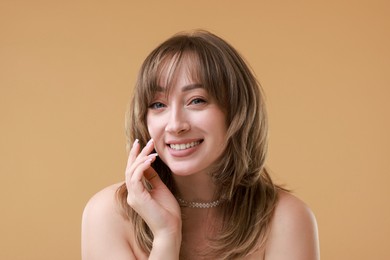 Photo of Attractive woman with stylish haircut on beige background