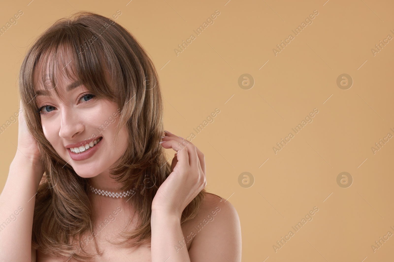 Photo of Attractive woman with stylish haircut on beige background, space for text