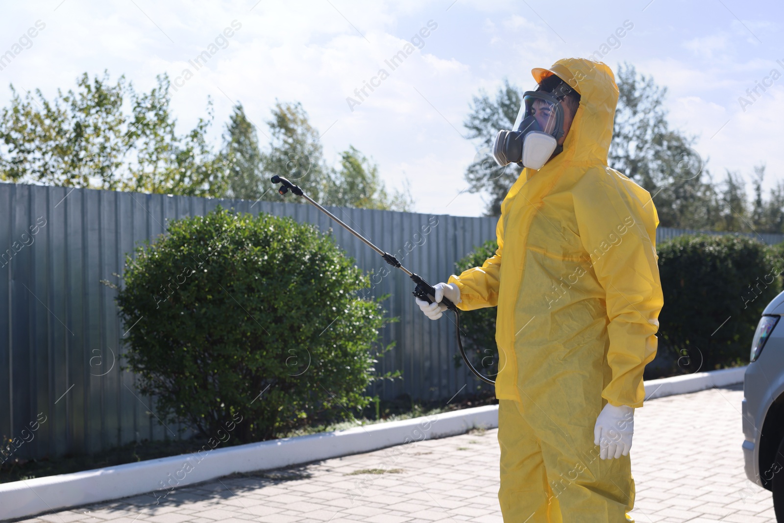 Photo of Pest control worker with spray tank outdoors