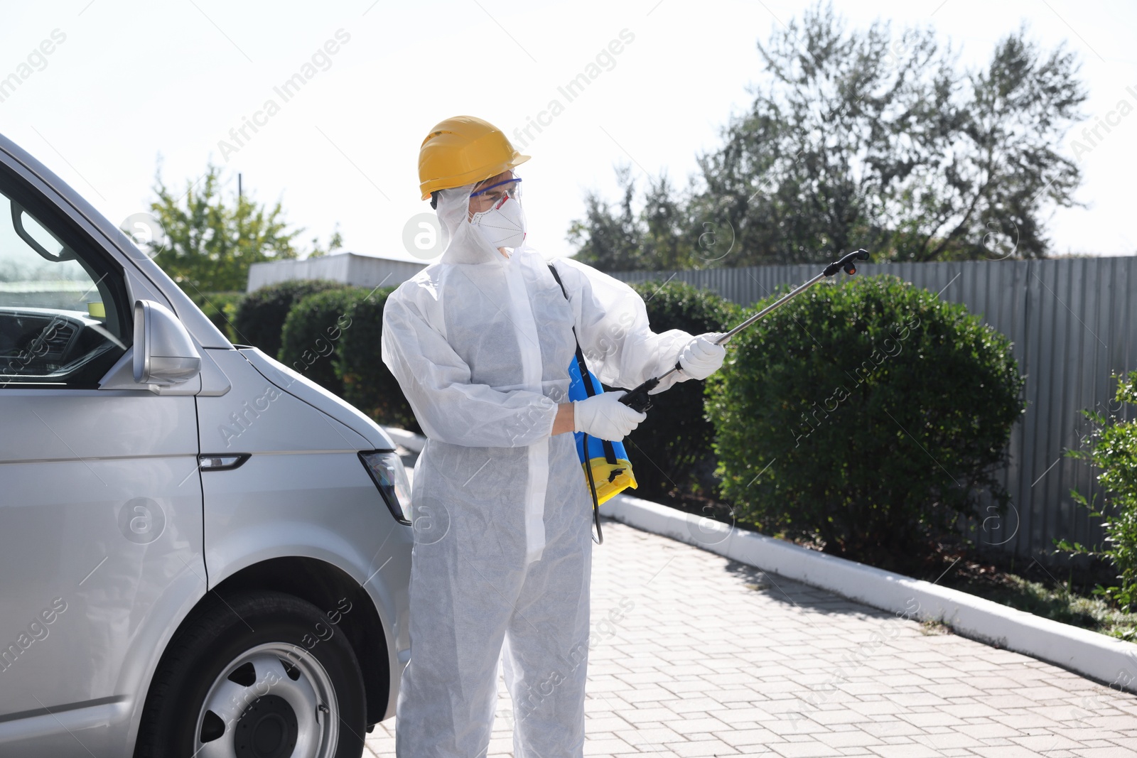 Photo of Pest control worker with spray tank outdoors