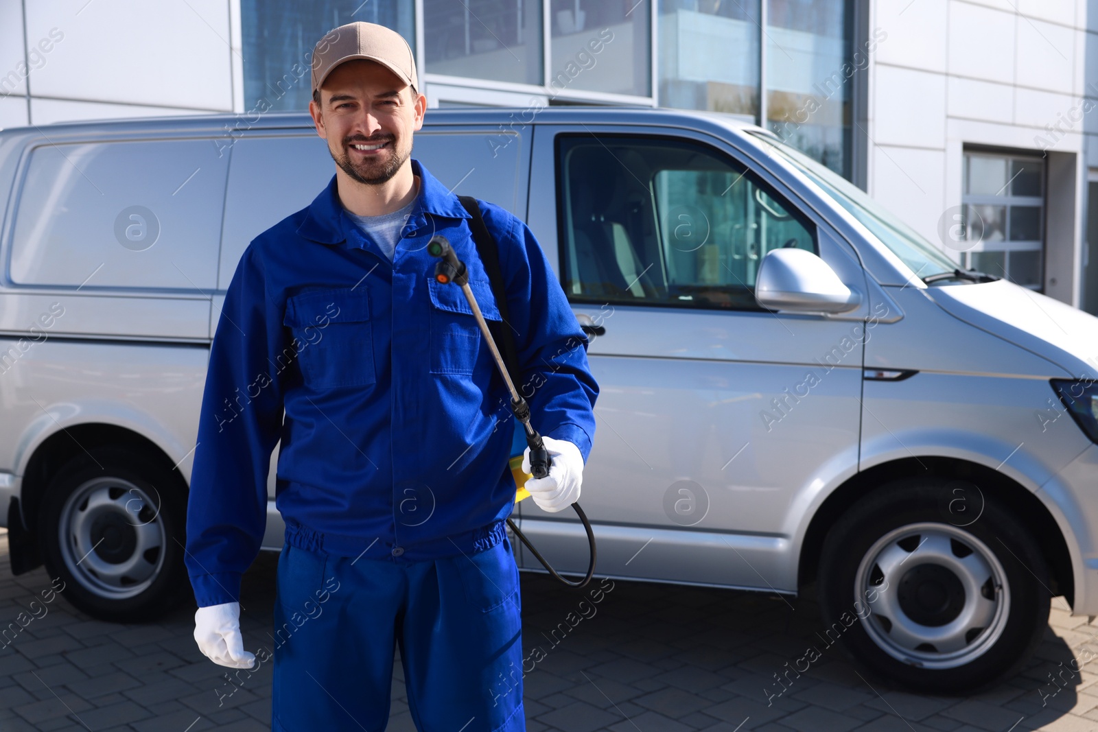 Photo of Pest control worker with spray tank outdoors