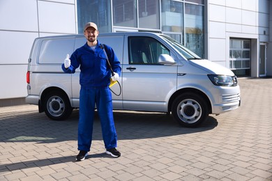 Photo of Pest control worker with spray tank outdoors