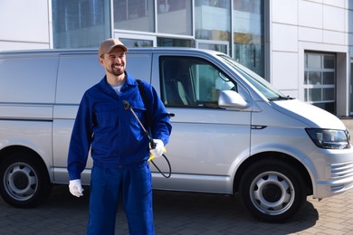 Photo of Pest control worker with spray tank outdoors