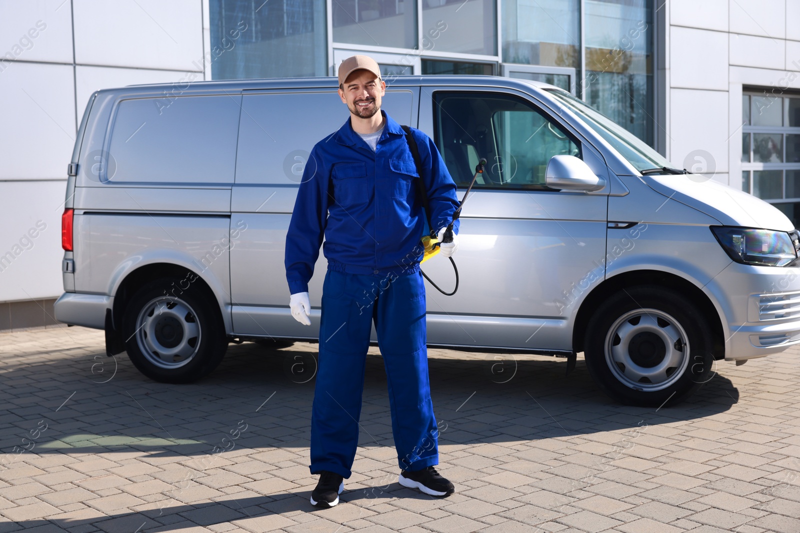 Photo of Pest control worker with spray tank outdoors