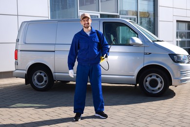 Photo of Pest control worker with spray tank outdoors