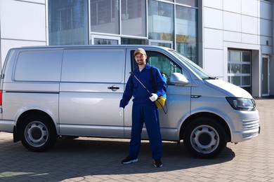 Photo of Pest control worker with spray tank outdoors