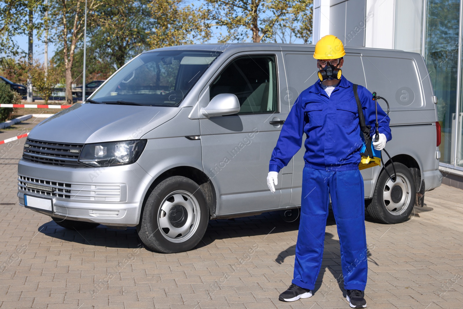 Photo of Pest control worker with spray tank outdoors