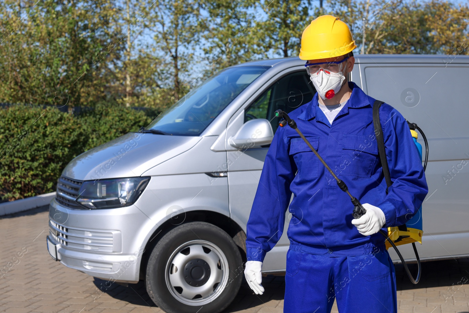 Photo of Pest control worker with spray tank outdoors