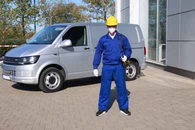 Photo of Pest control worker with spray tank outdoors