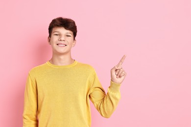 Photo of Portrait of happy teenage boy on pink background, space for text